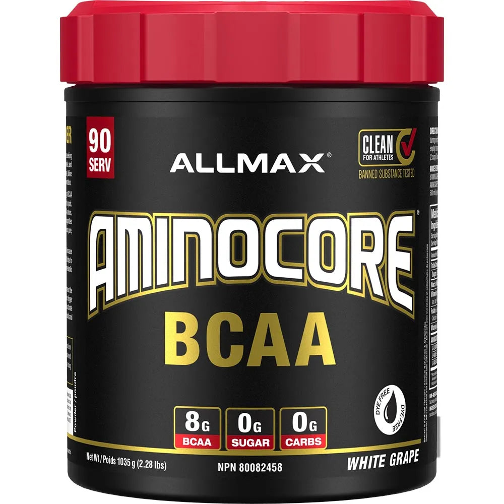A tub of Allmax Aminocore BCAA dietary supplement powder in White Grape flavor. The container is black with a bright red lid, featuring gold and white branding text.