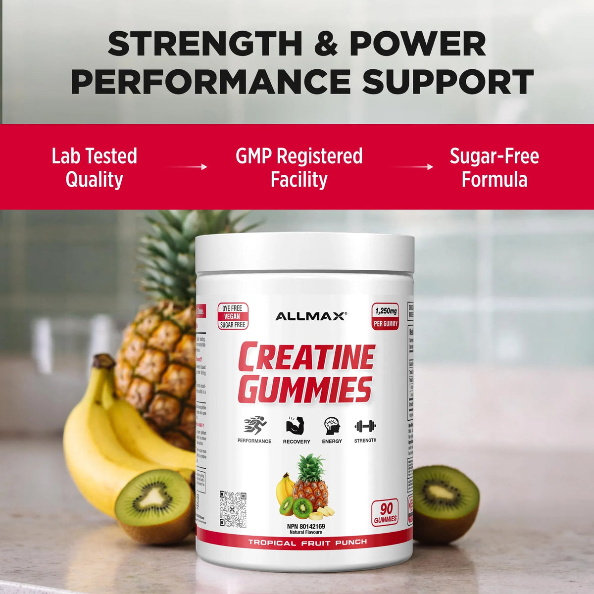 A tub of ALLMAX Creatine Gummies in Tropical Fruit Punch flavor, displayed on a kitchen counter with bananas, kiwi, and a pineapple in the background. The image includes a top banner with marketing text: 'STRENGTH & POWER PERFORMANCE SUPPORT' and three feature callouts: 'Lab Tested Quality', 'GMP Registered Facility', and 'Sugar-Free Formula'.